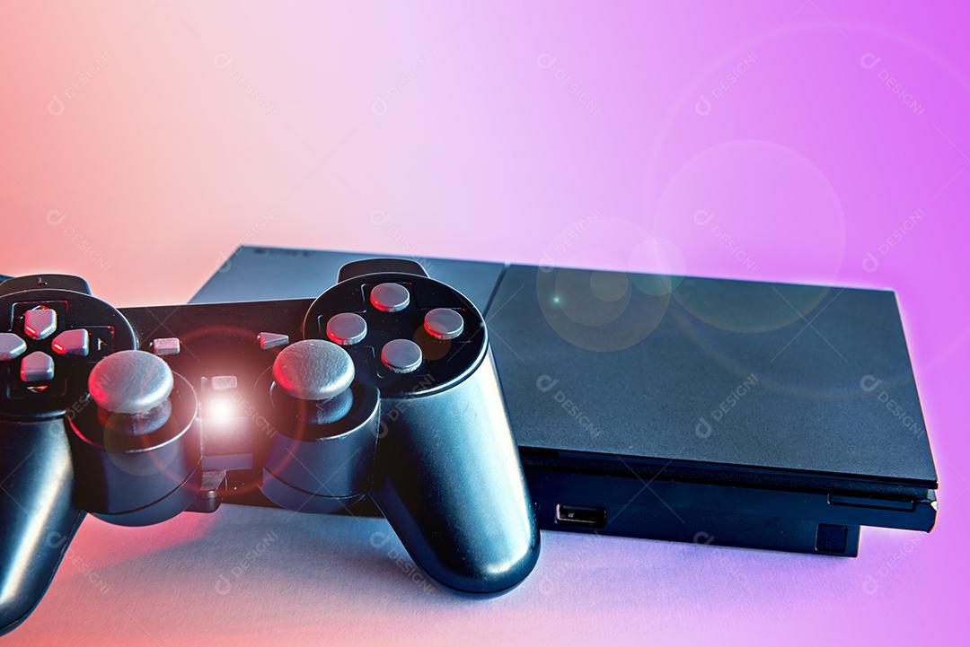 Antigo console de videogame em fundo colorido.