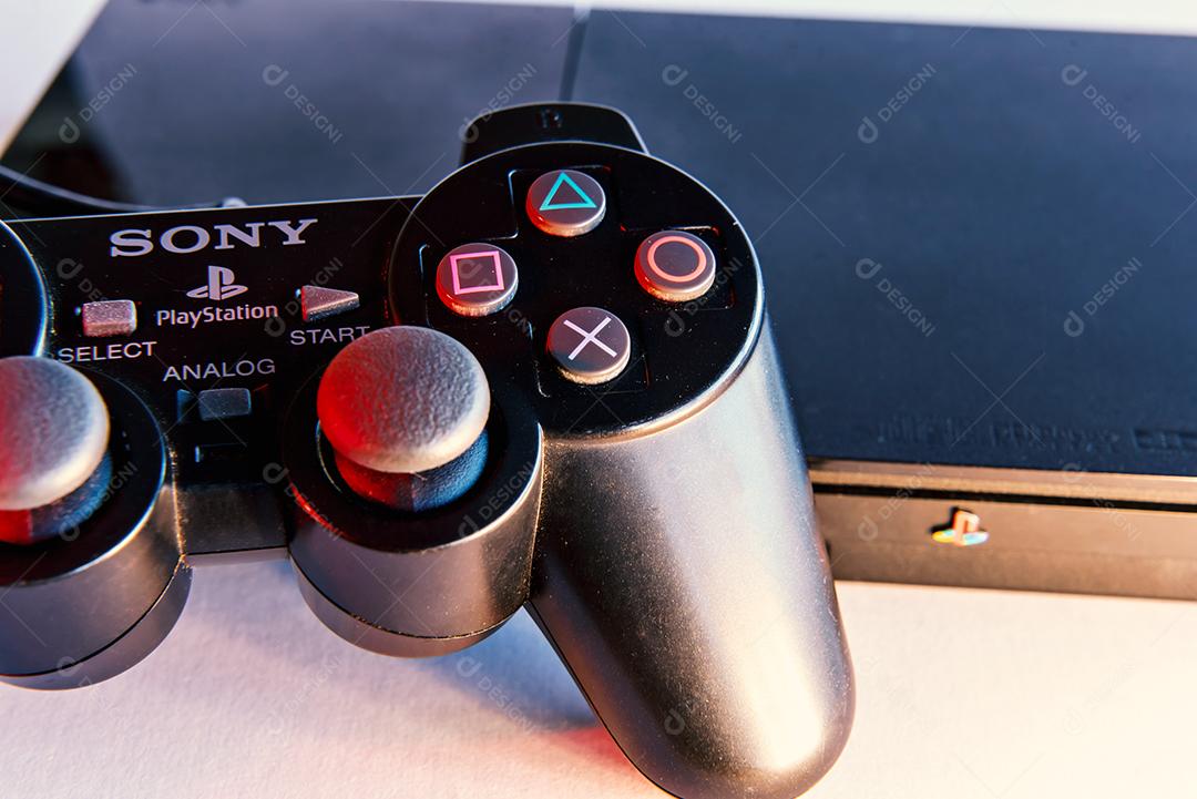 Consoles de videogame antigos em fundo branco com luzes vermelhas.