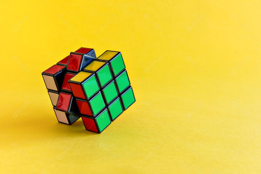 Cubo mágico de Rubik em fundo amarelo.