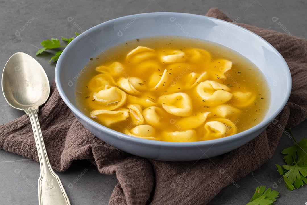 Sopa de cappelletti ou tortellini brodo em uma tigela com tempero ov