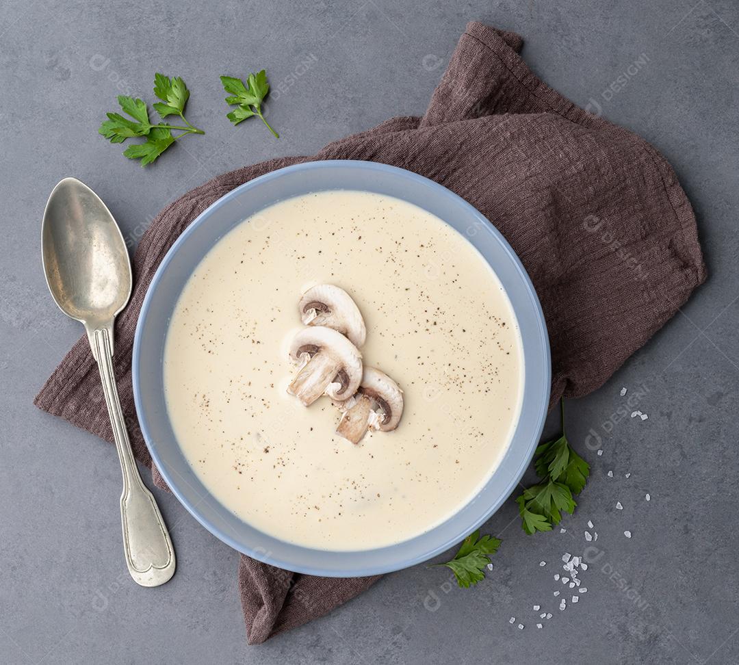 Sopa de cogumelos em uma tigela com temperos sobre fundo de pedra