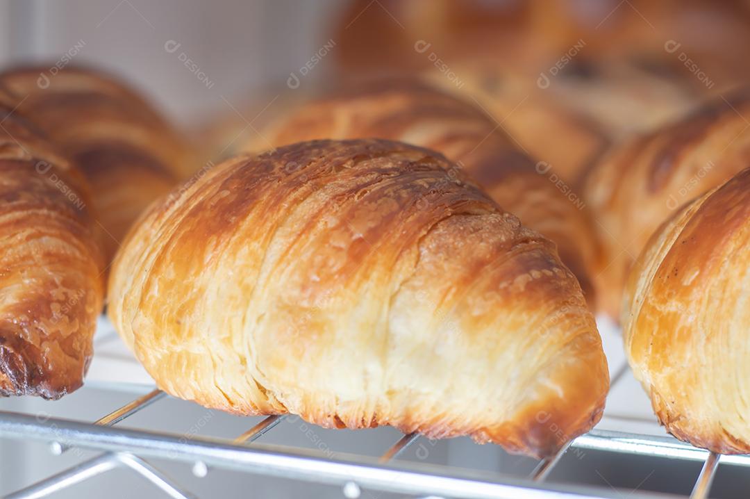 Croissant francês recentemente apoiado brilhante nos raios do sol da manhã, luz natural.