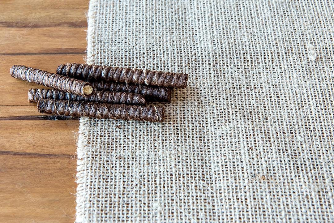 Canudos de chocolate na mesa de madeira.