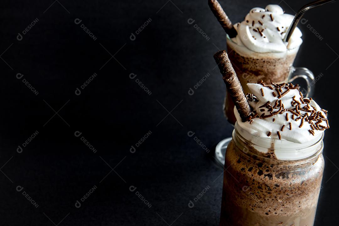 Café frappe frio com chantilly. Fundo preto com frappuccino gelado.