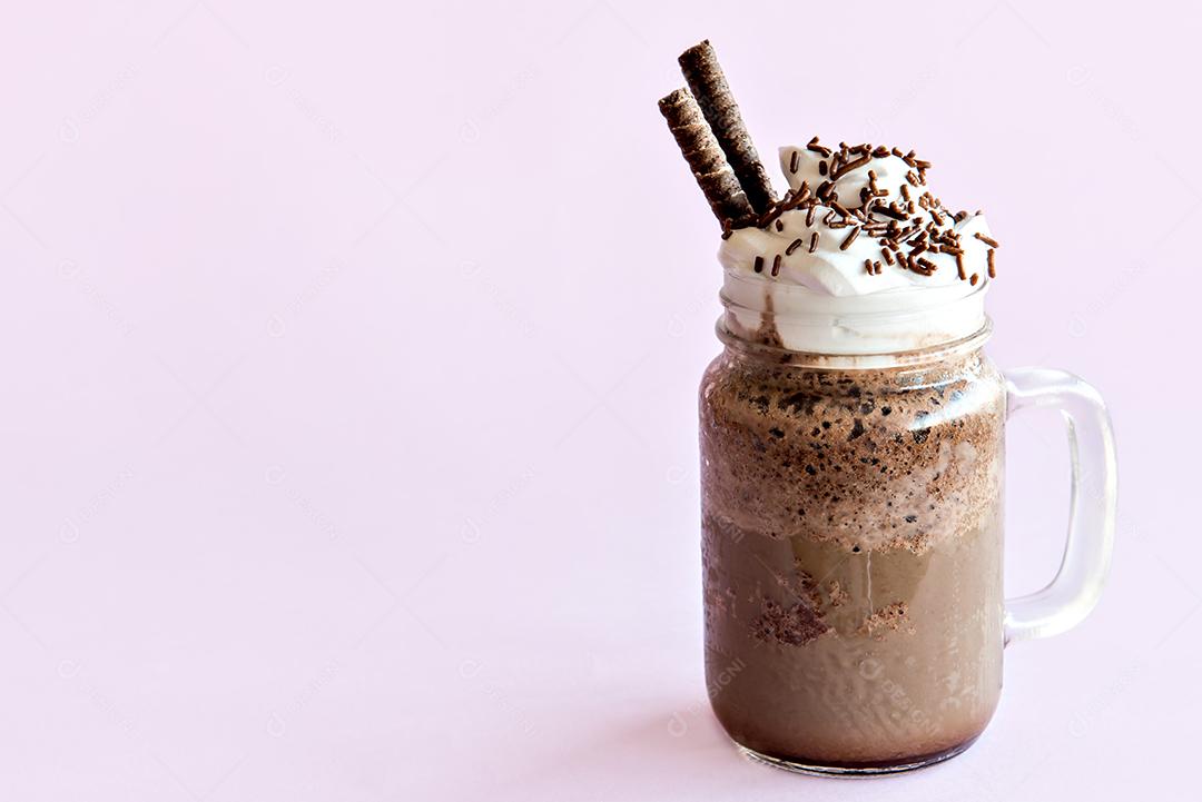 Café frappe frio com chantilly. Fundo rosa com frappuccino gelado.