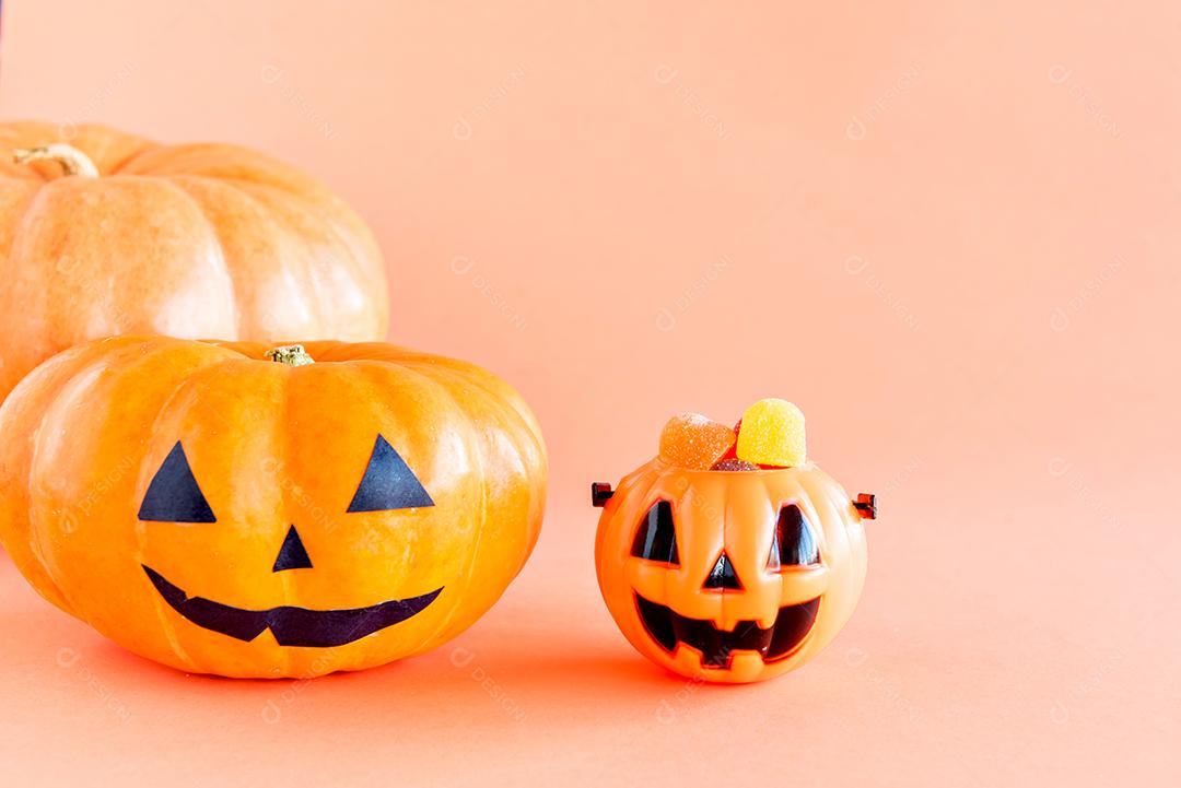 Happy Halloween decoration. Pumpkin and gummy candies on orange background