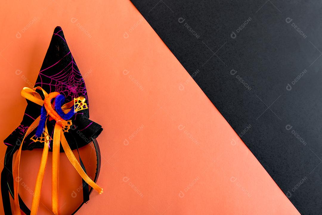 Decoração de feliz dia das bruxas. Chapéu de bruxa em fundo laranja.