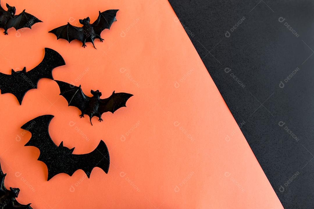 Decoração de feliz dia das bruxas. Morcegos e fantasmas em fundo laranja.