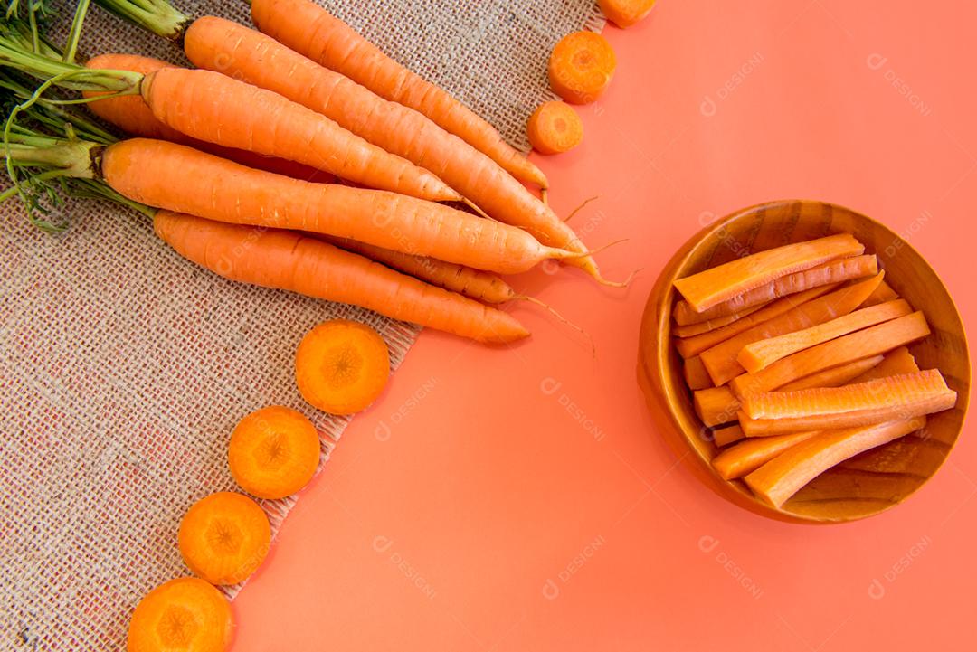 Cenoura em uma mesa com fundo laranja.