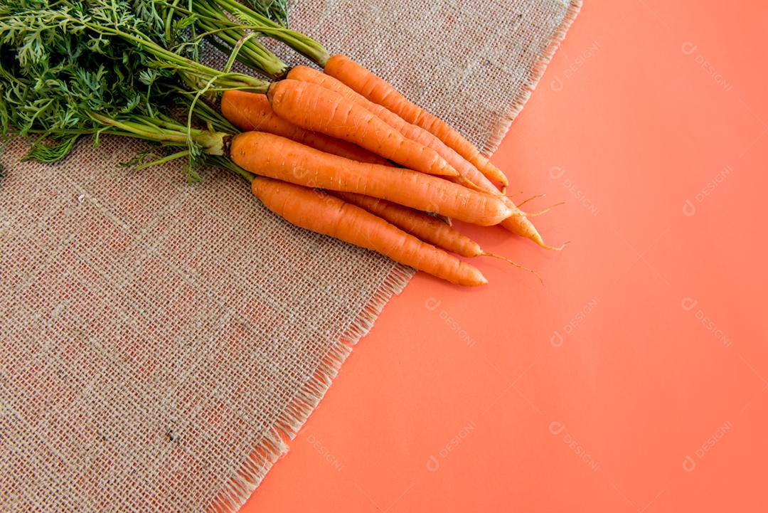 Cenoura em uma mesa com fundo laranja.