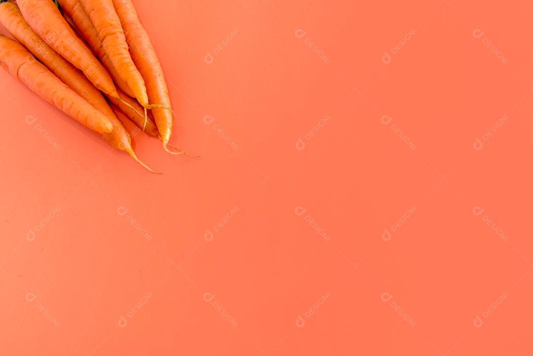 Cenouras em fundo laranja com espaço para texto.