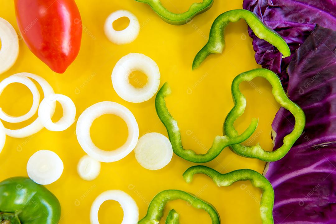 Legumes, repolho, cebola, tomate e pimentão em backgro amarelo