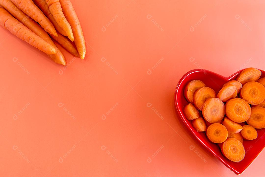 Um monte de cenouras em um fundo laranja, cenouras fatiadas