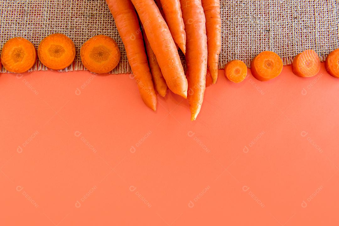 Um monte de cenouras em um fundo laranja, cenouras fatiadas