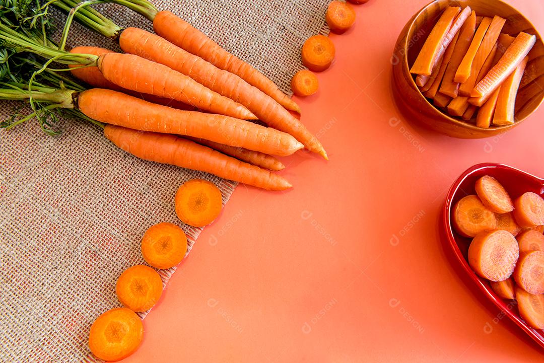 Um monte de cenouras em um fundo laranja, cenouras fatiadas