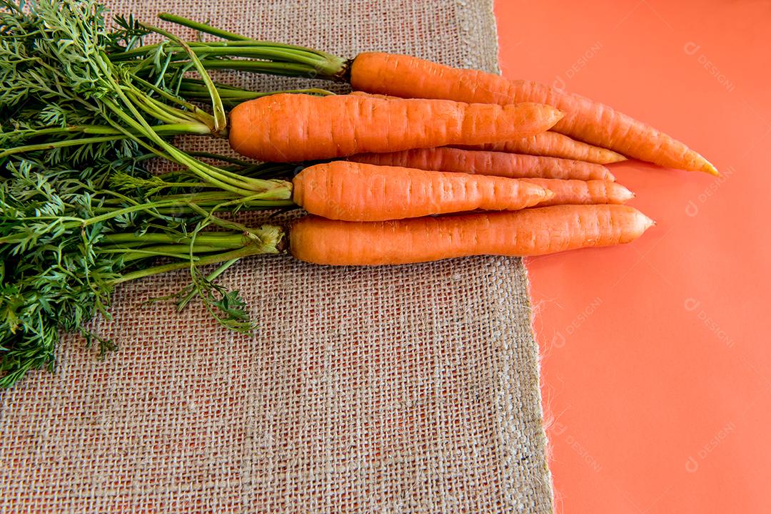 Um monte de cenouras em um fundo laranja, cenouras fatiadas