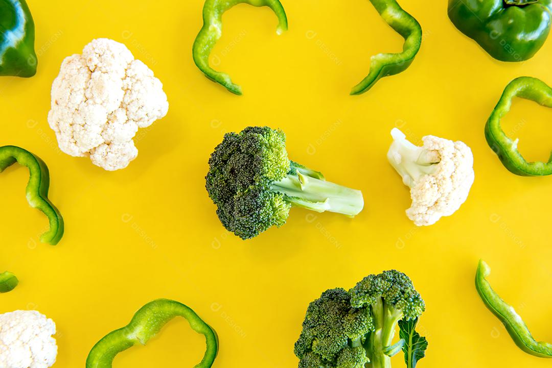Brócolis, pimentão e couve-flor em fundo amarelo.