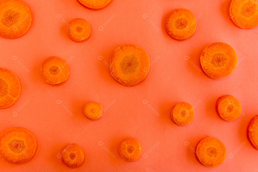 Fatias de cenoura na vista superior de fundo laranja.