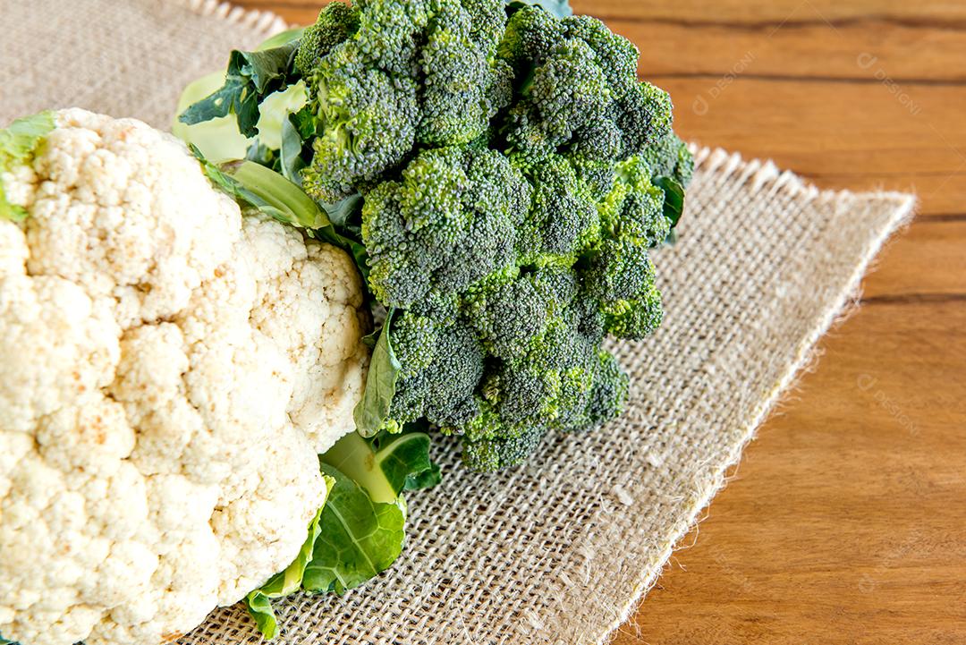 Brócolis e couve-flor em uma mesa de madeira.
