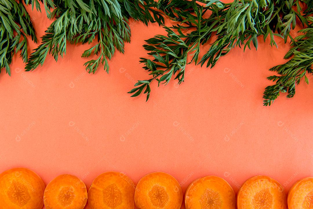 Fatias de cenoura em fundo laranja.