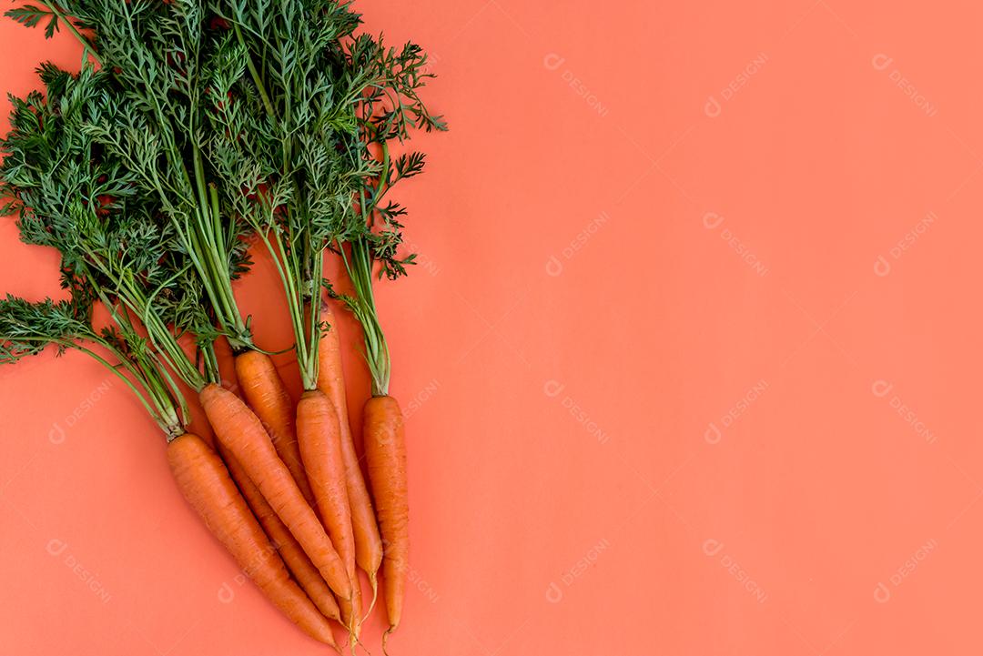 Cenouras em uma mesa com fundo laranja.