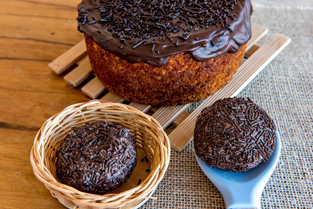 Bolo de chocolate e bombom de brigadeiro na mesa.