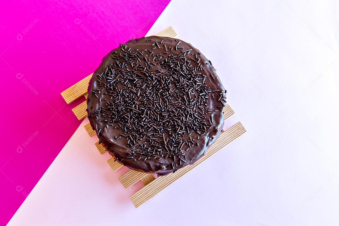 Bolo de chocolate no fundo rosa. Vista do topo.