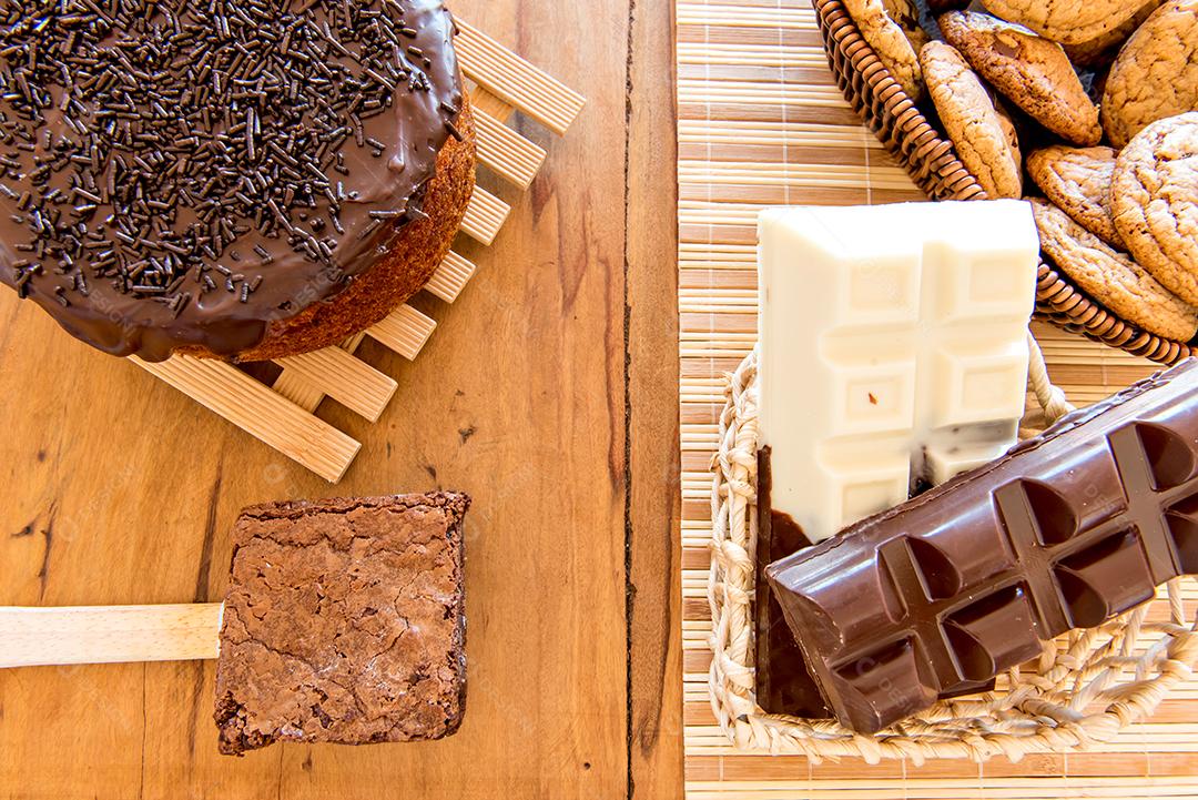 Doces na mesa. Bolo de chocolate, biscoitos e barra de chocolate.