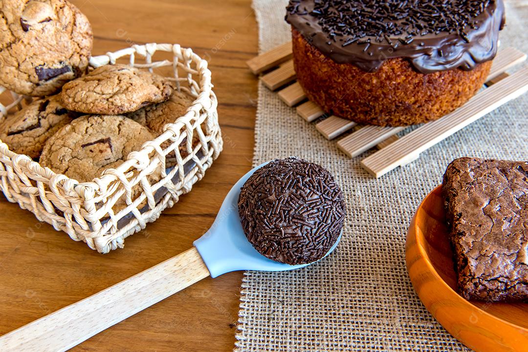 Doces na mesa. Bolo de chocolate, biscoitos, brownie e chocolate