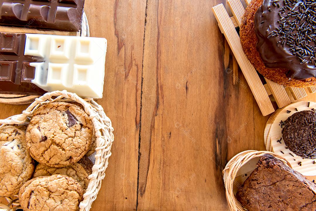 Doces na mesa. Bolo de chocolate, biscoitos e barra de chocolate.