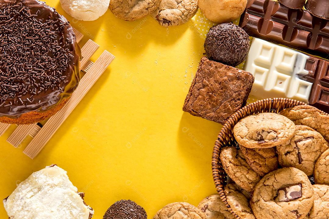 Doces na mesa. Bolo de chocolate, biscoitos e barra de chocolate.