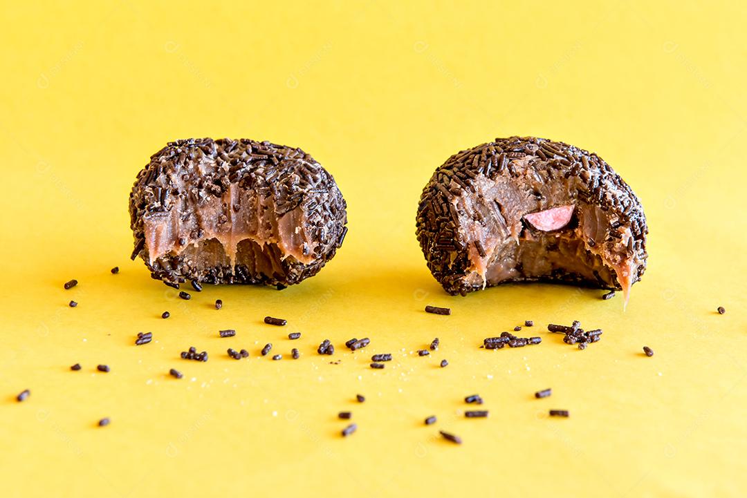 Brigadeiro de chocolate em fundo amarelo.