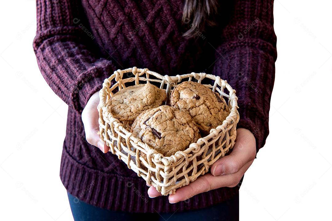 Menina segurando biscoitos de chocolate na cesta de coração.