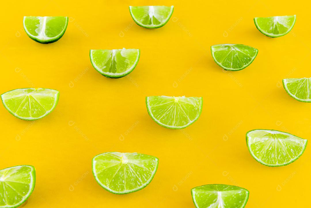Limões fatiados em fundo amarelo.