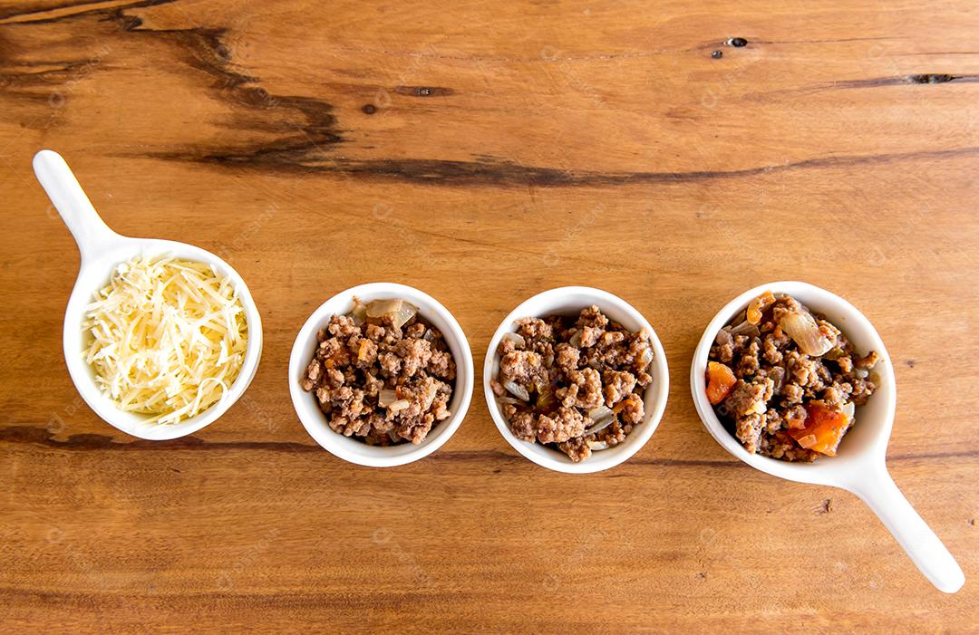 Queijo e carne moída em uma mesa de madeira