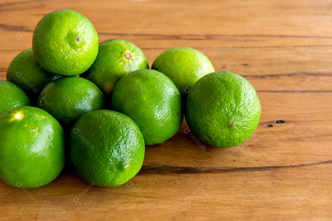 Limões em uma mesa de madeira, frutas cítricas.
