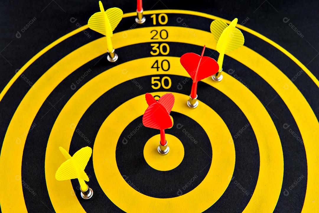 Jogo de dardos, alvo de dardos com dardo vermelho no centro.