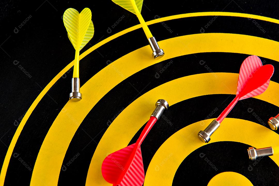Jogo de dardos, alvo de dardos com dardo vermelho no centro.