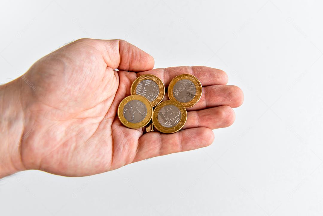 Mão segurando moedas comemorativas brasileiras, moedas reais brasileiras