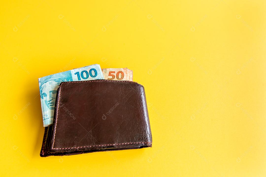 Carteira com dinheiro brasileiro, notas reais brasileiras na parte traseira amarela