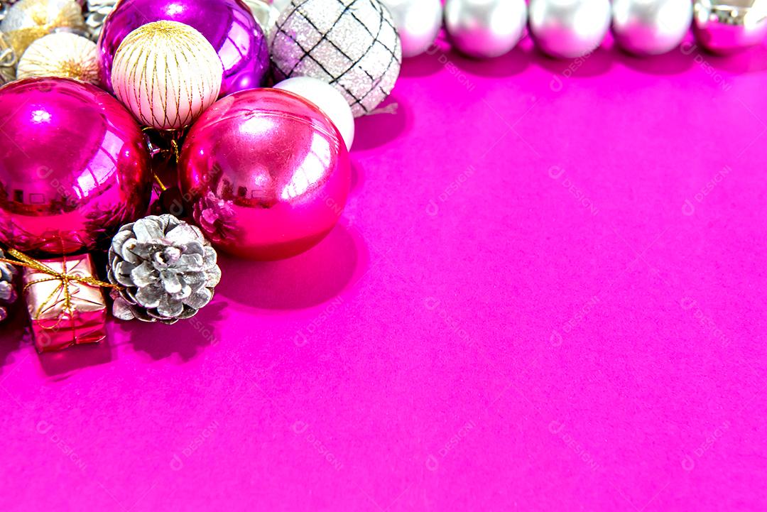 Christmas baubles and ornaments on a pink background