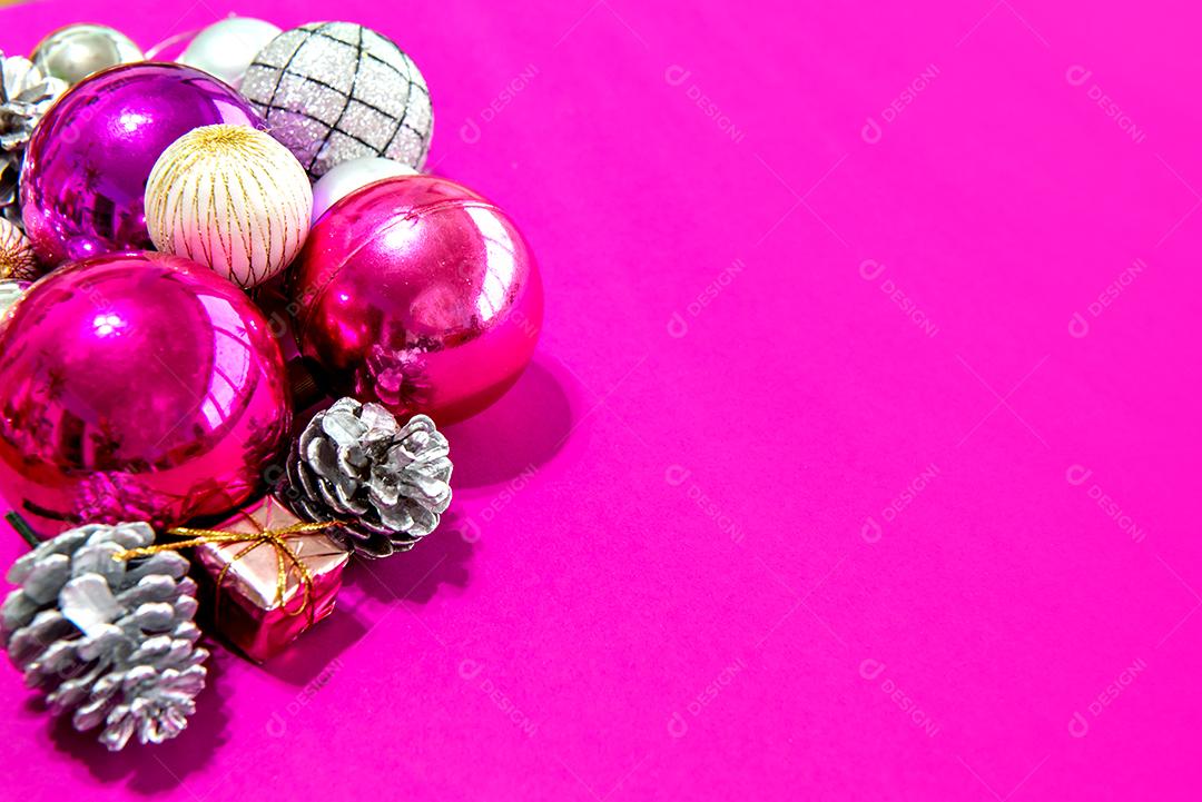 Bolas de natal e enfeites em um fundo rosa
