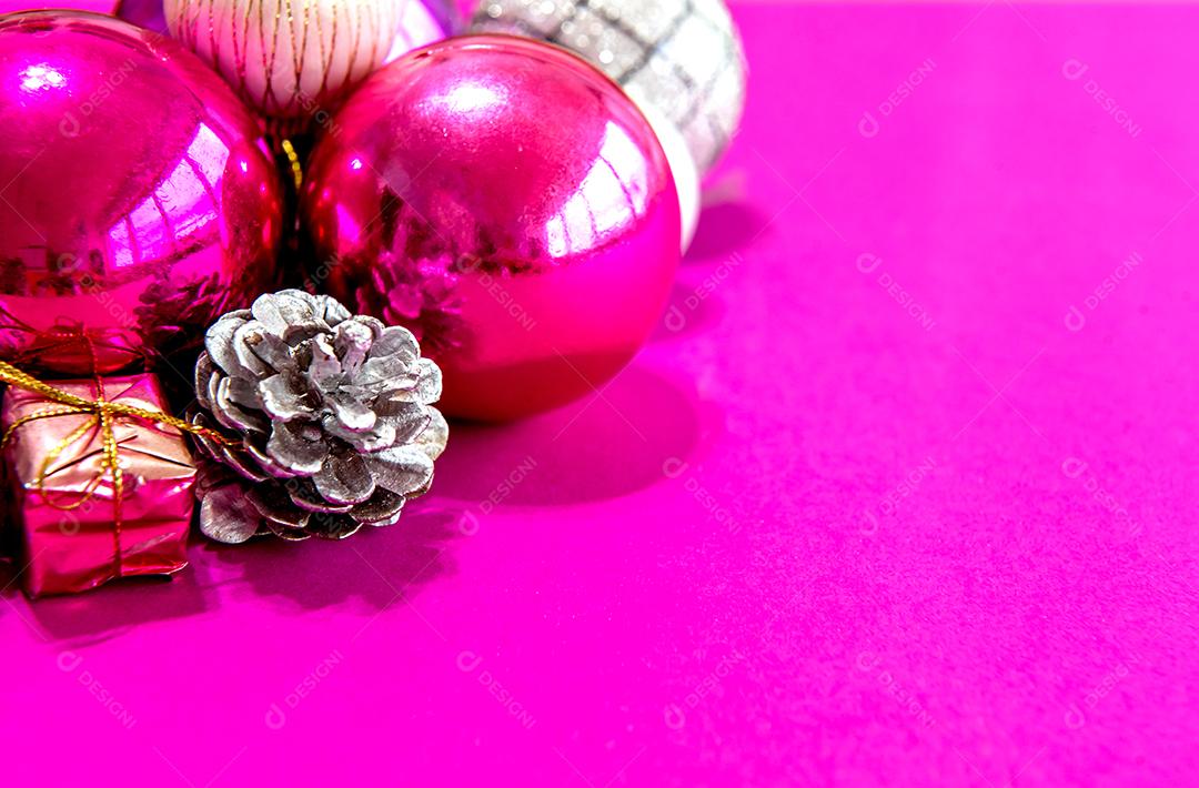 Christmas baubles and ornaments on a pink background