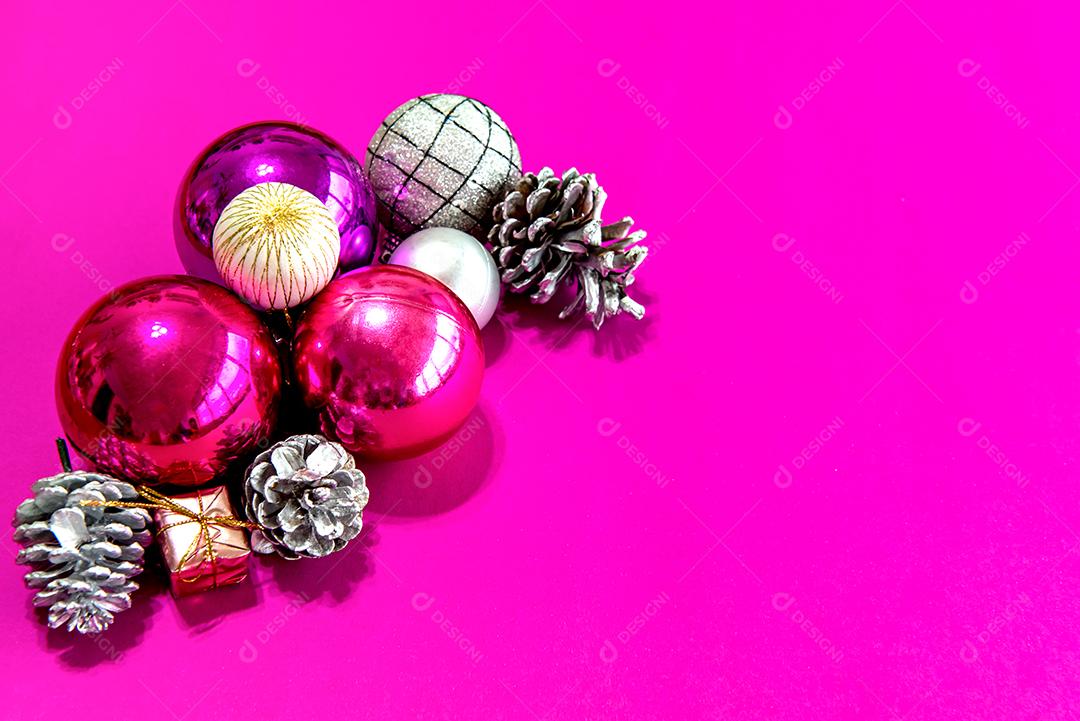 Bolas de natal e enfeites em um fundo rosa
