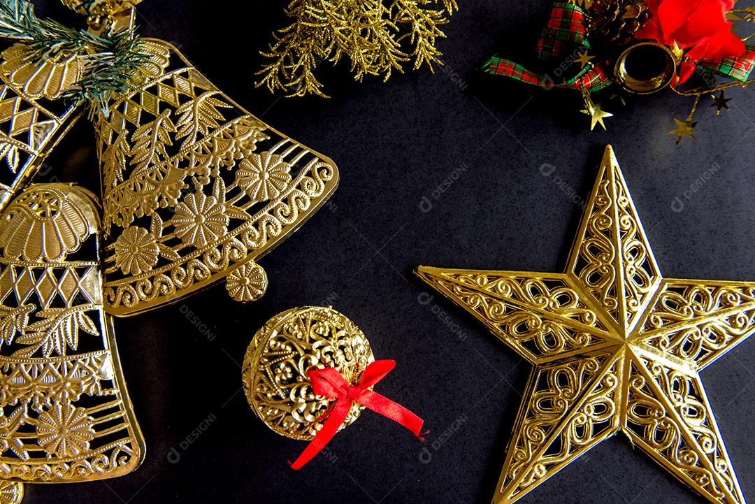 Enfeites de Natal dourados sobre fundo preto.