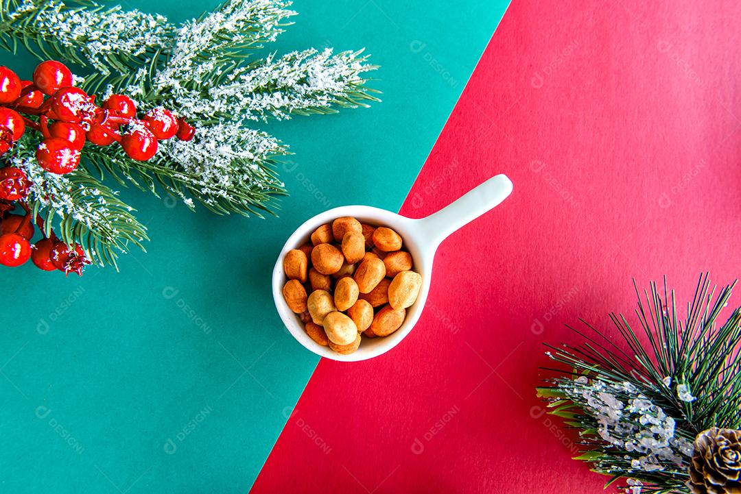 amendoins na mesa de natal com fundo verde e vermelho
