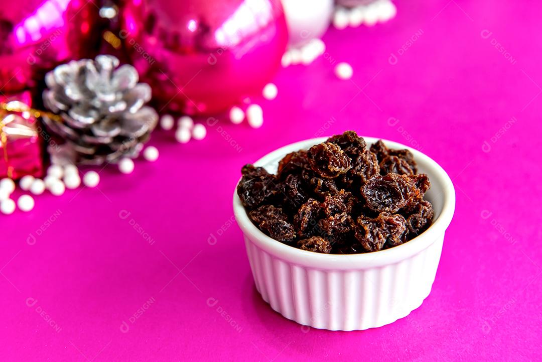 Uvas passas no fundo rosa de natal.