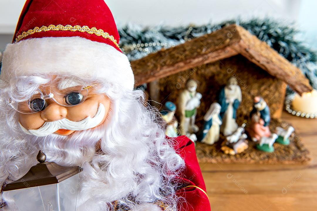 Papai Noel com presépio ao fundo