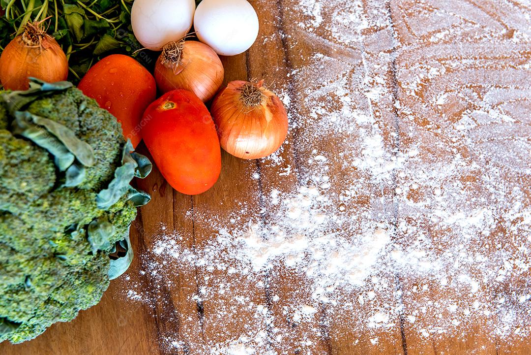 Fundo de madeira com legumes e farinha. Vista do topo.