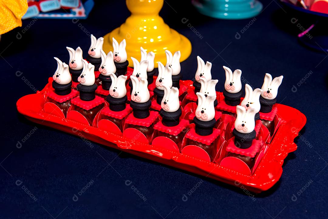 Mesa com doces e muffins decorados com glacê real